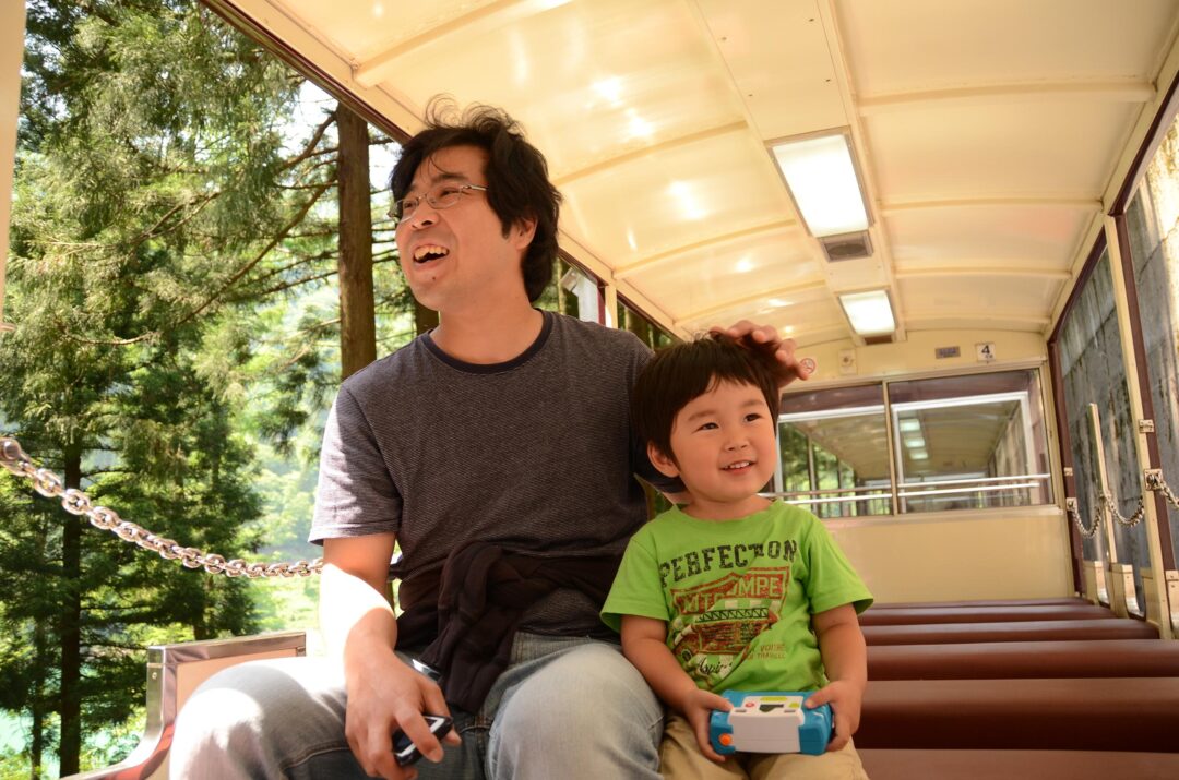 【3】『トロッコ電車で冒険のスタート』新緑の中を走り出したトロッコ電車にワクワクを隠せない親子です